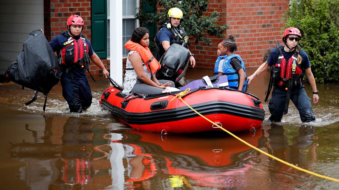 Rescue personnel help people evacuate a flooded area in Spring Lake, North Carolina.