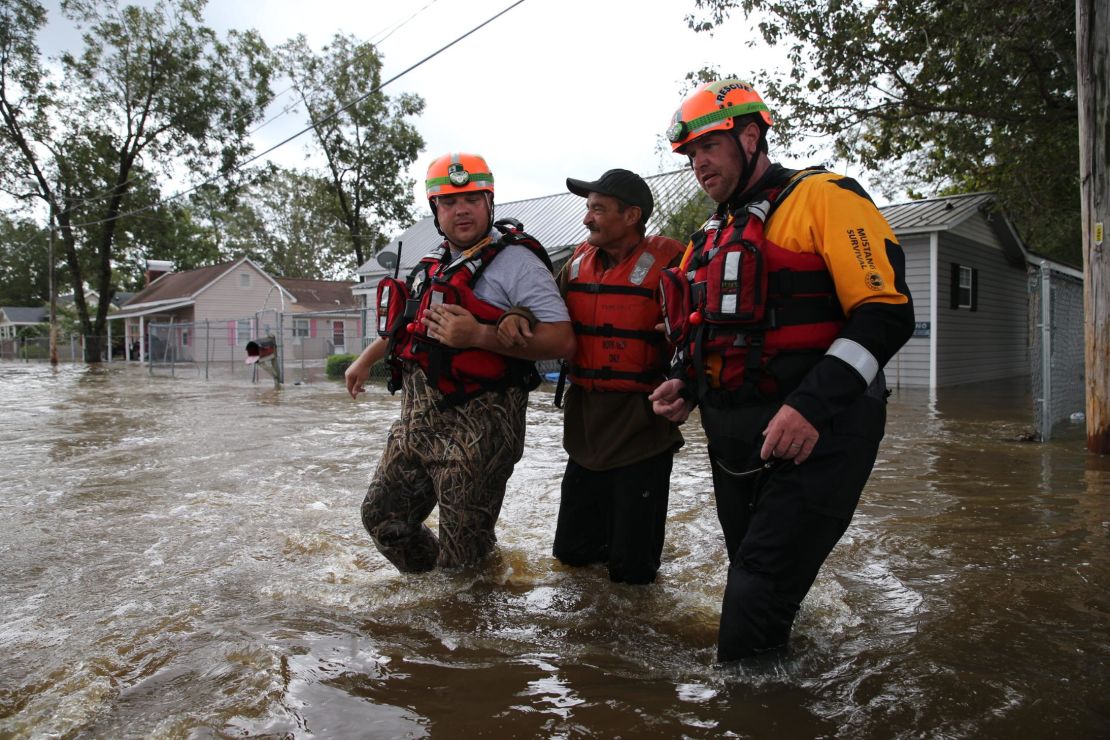 Lumberton Fire and Rescue members help a resident through floodwaters on Monday.