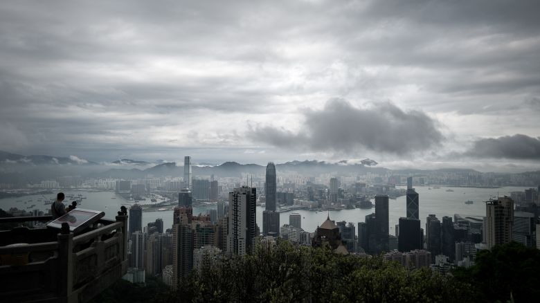 A man (L) looks at the city's skyline as a storm approaches in Hong Kong on April 2, 2014. Stormy weather is affecting the city due to a trough of low pressure on coastal areas of neighbouring Guangdong province in southern China.