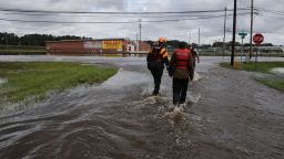 Lumberton North Carolina Fire and Rescue members help a resident walk through flooded waters in Lumberton, North Carolina on September 17, 2018. - Catastrophic floods raised the threat of landslides and dam failures across the southeastern United States on Monday, prolonging the agony caused by a killer hurricane that has left more than a dozen people dead and caused billions of dollars in damage. Downgraded to a tropical depression, Florence crept over South and North Carolina, dumping heavy rains on already flood-swollen river basins that authorities warned could bring more death and destruction. (Photo by Alex EDELMAN / AFP)       (Photo by Alex Edelman/Getty Images)