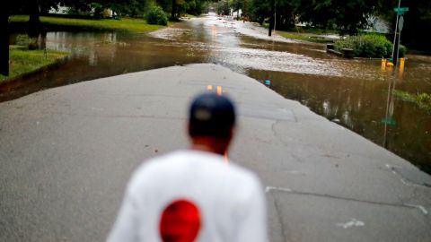 Helen McKoy walks down a flooded street in her neighborhood in Fayetteville on Sunday.