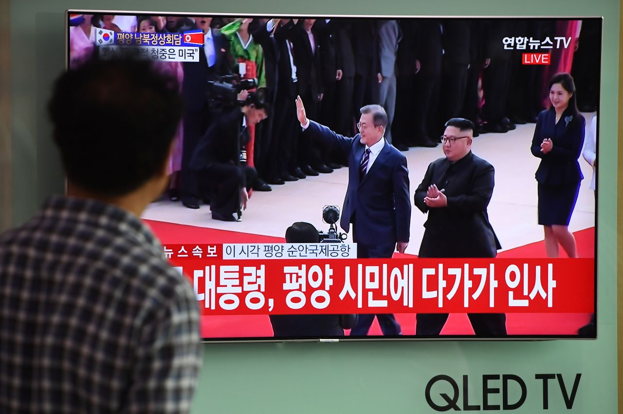 People watch live footage from the summit at a railway station in Seoul on September 18. 