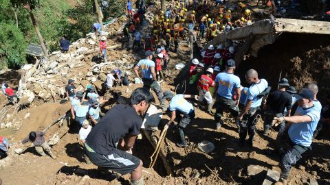 Rescuers dig on the remains of a building which was swept away by the landslide.