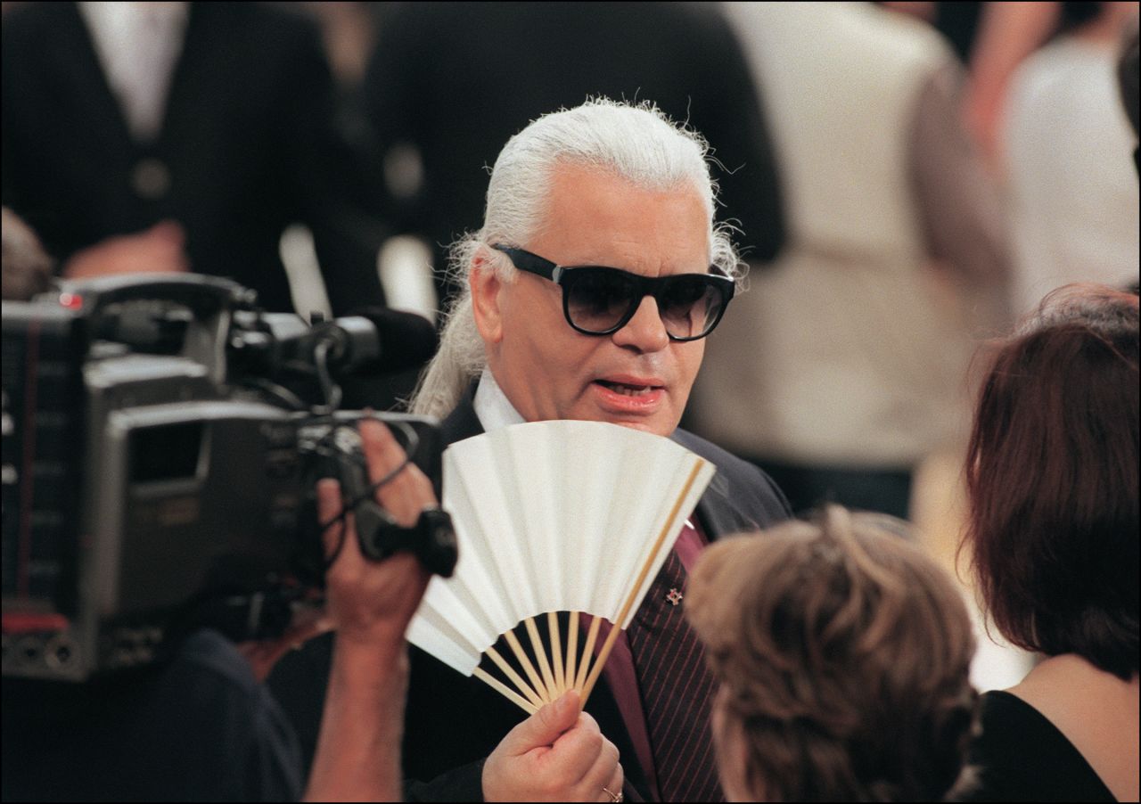 Lagerfeld fans himself during Chanel's Autumn-Winter 1999 haute couture show.