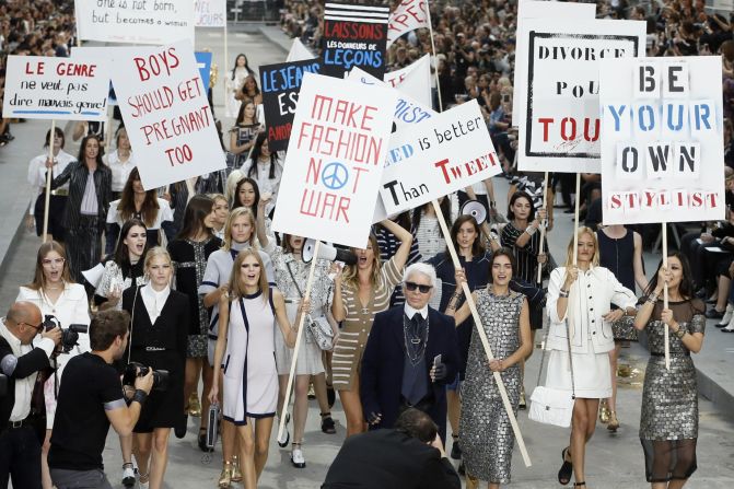 Lagerfeld, surrounded by models, walks the runway after the protest-themed Spring-Summer 2015 Chanel show.