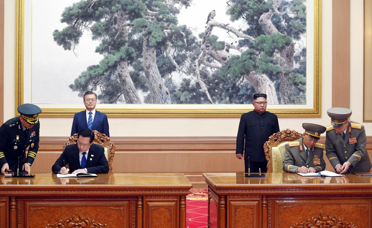 South Korean Defense Minister Song Young-moo, second from left, and his North Korean counterpart No Kwang Chol sign a military agreement, vowing to "cease all hostile acts against each other."
