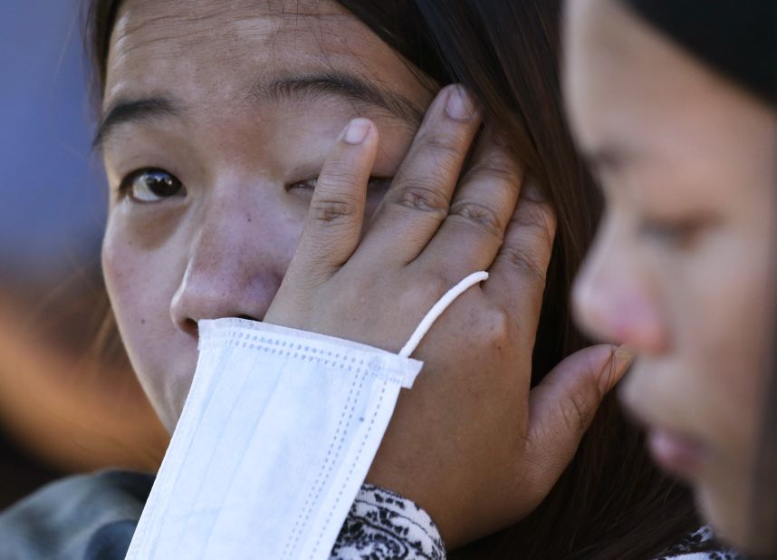 Evelyn Wigan wipes away a tear as she waits for news of missing relatives who were near the site of a deadly landslide in Itogon, Philippines.