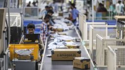 An employee uses a laptop computer while packages move along a conveyor belt at the Amazon.com Inc. fulfillment center in Hyderabad, India on Thursday, Sep 7, 2017. Amazon opened its largest Indian fulfillment center in Hyderabad. The center spans 400,000 square feet with 2.1m cubic feet of storage capacity the company said in a statement. Photographer: Dhiraj Singh/Bloomberg via Getty Images