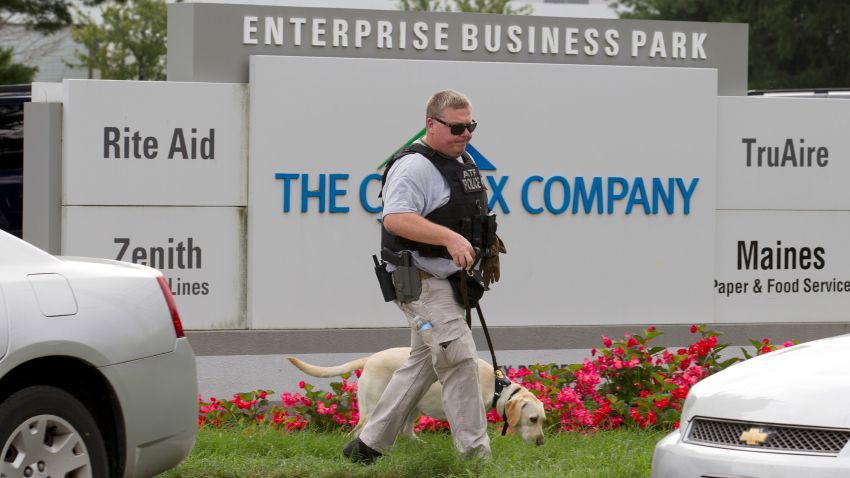 ATF police officer with a sniffing dog walks out the industrial complex in Harford County, Md., Thursday, Sept. 20, 2018.   Authorities say multiple people have been shot in northeast Maryland in what the FBI is describing as an "active shooter situation."  (AP Photo/Jose Luis Magana)