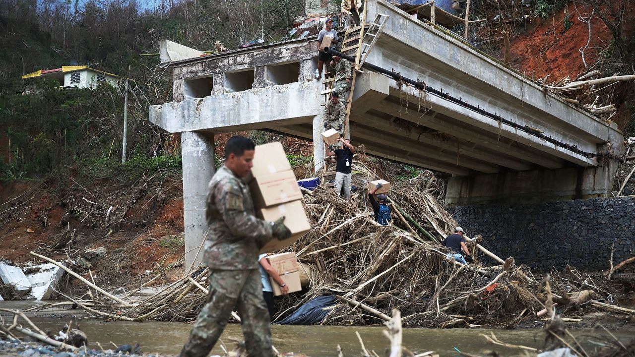 Supplies are carried to a makeshift ladder after a bridge collapse in Utuado.  