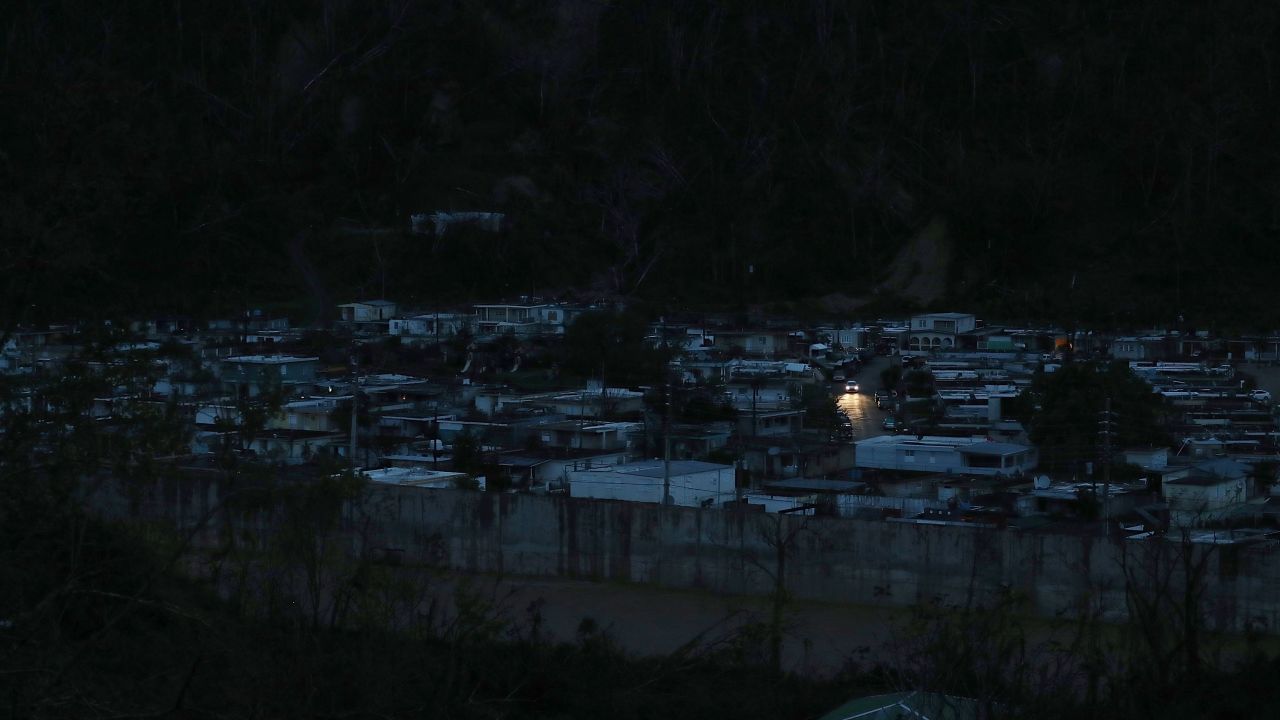 Car lights are seen in a powerless neighborhood of Utuado, three weeks after the hurricane.