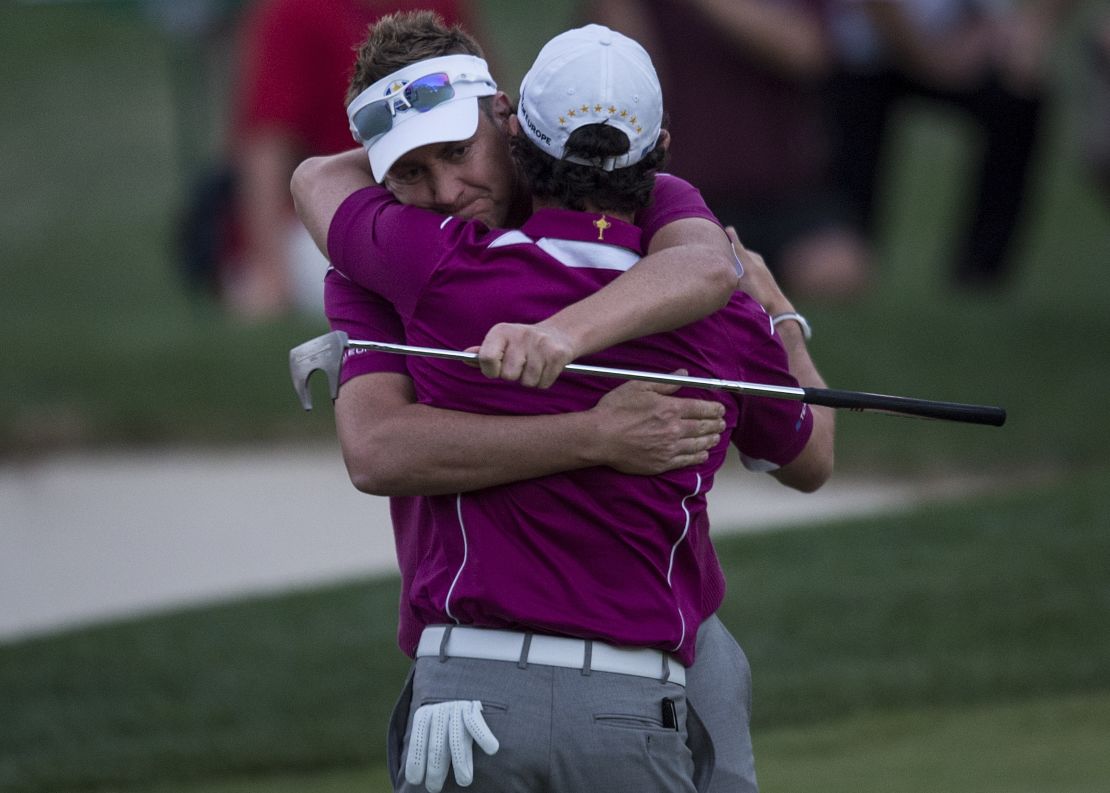 Ian Poulter and partner Rory McIlroy embrace after winning their match in 2012. 