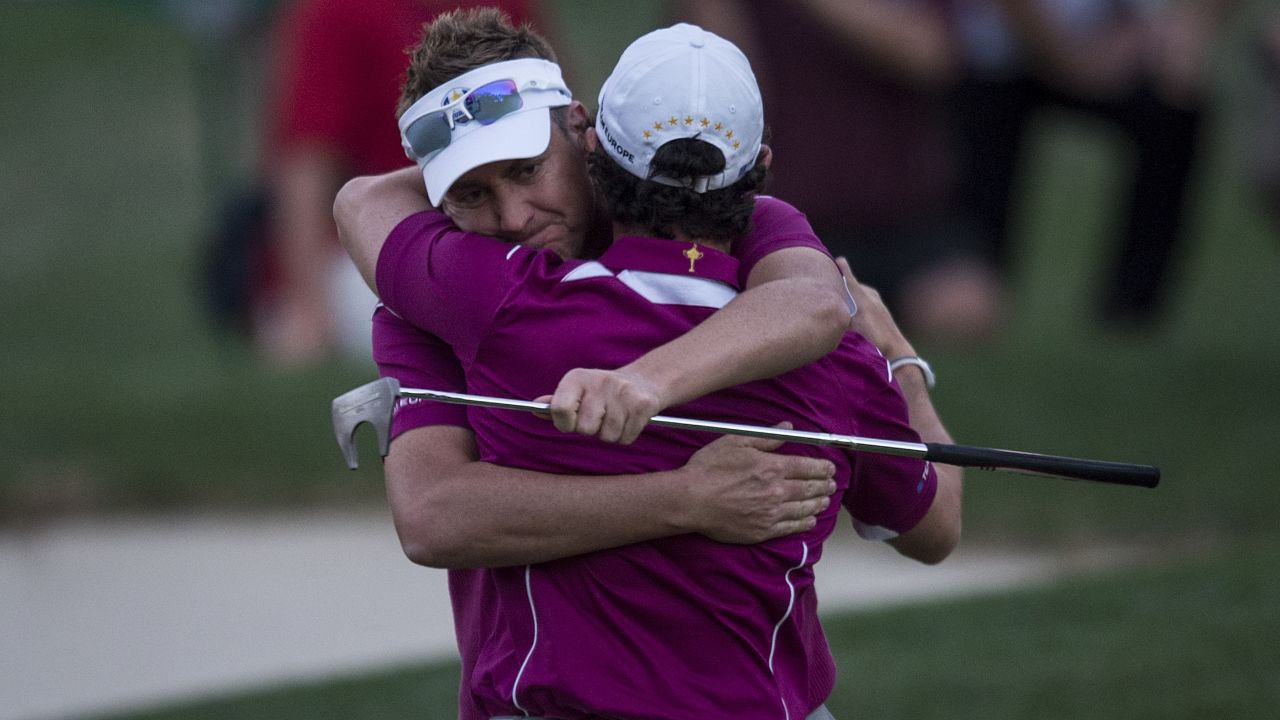 Ian Poulter and partner Rory McIlroy embrace after winning their match in 2012. 