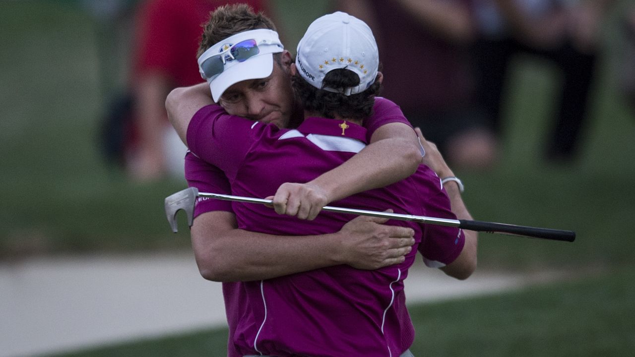 Ian Poulter and partner Rory McIlroy embrace after winning their match in 2012.