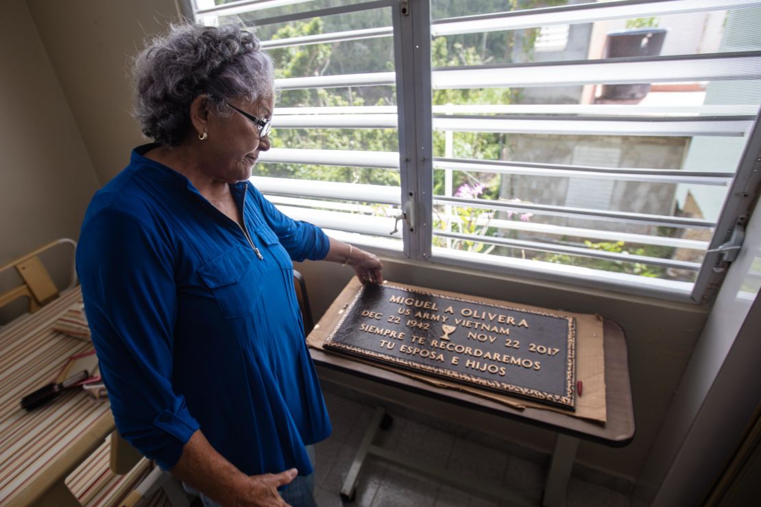 Diana Aponte looks at a memorial to her husband, who died two months after the storm.