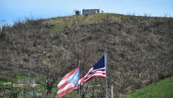 US and Puerto Rican flags wave next to Hiighway 30 in eastern Puerto Rico after Hurricane Maria.