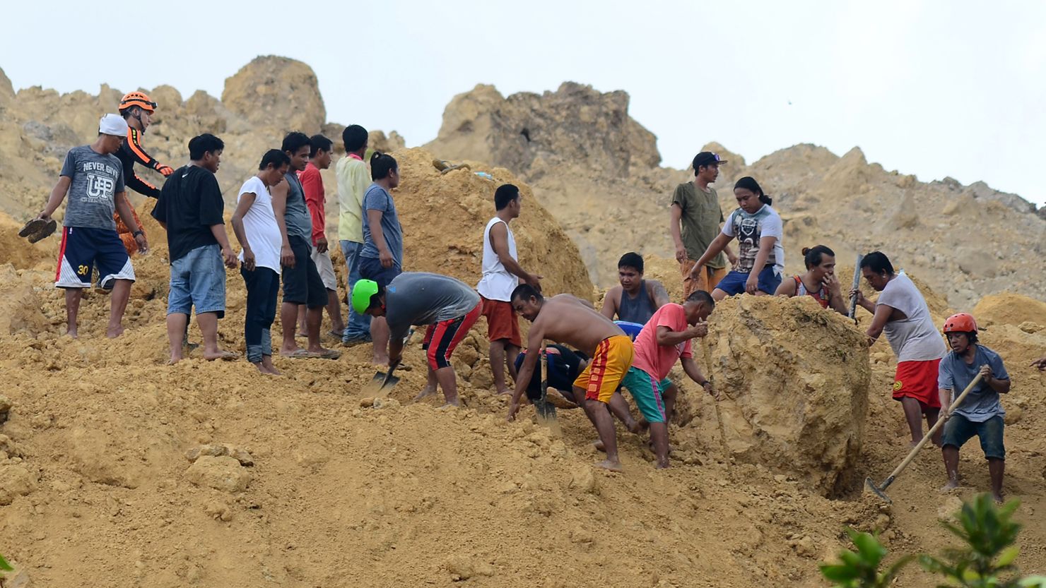 Residents dig amongst boulders as they search for survivors after a landslide triggered by monsoon rains hit a village in Naga City, Cebu province in central Philippines on September 20, 2108.