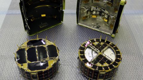 The small rovers, MINERVA-II1. Rover-1A is on the left and Rover-1B is on the right. Behind the rovers is the cover in which they are stored.