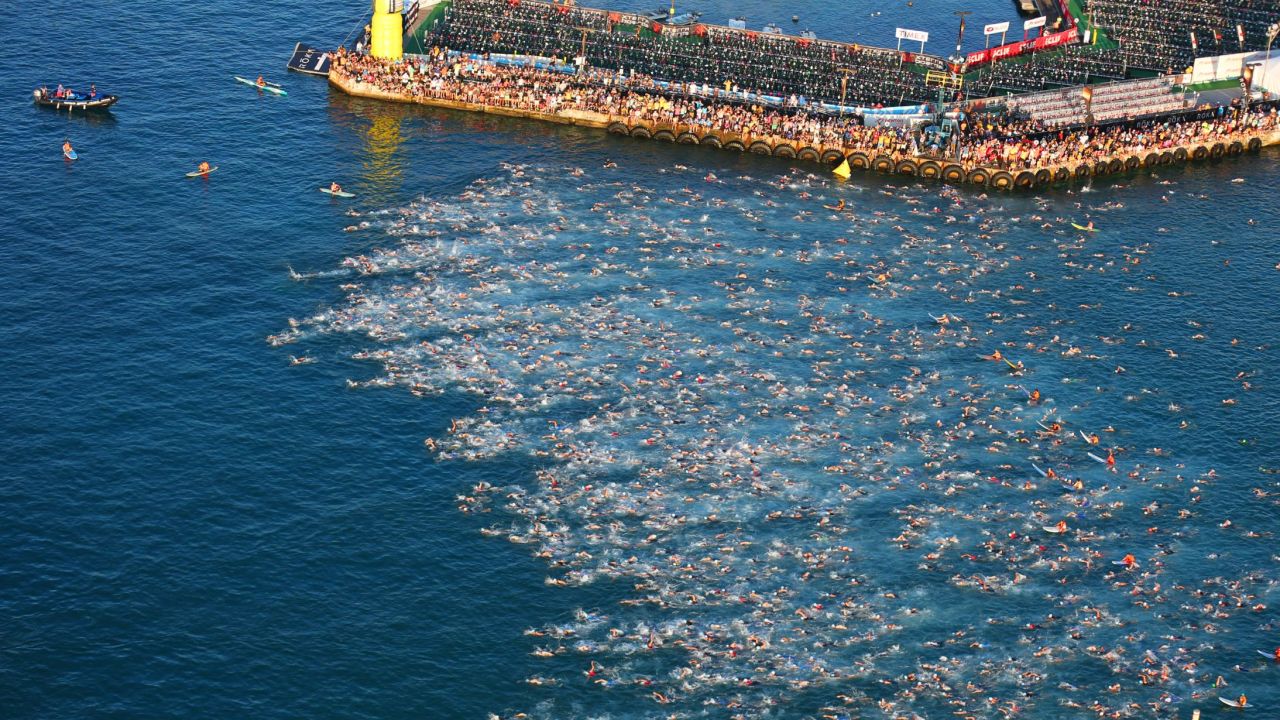 Triathletes begin the 140.6-mile course with a 2.4-mile swim.