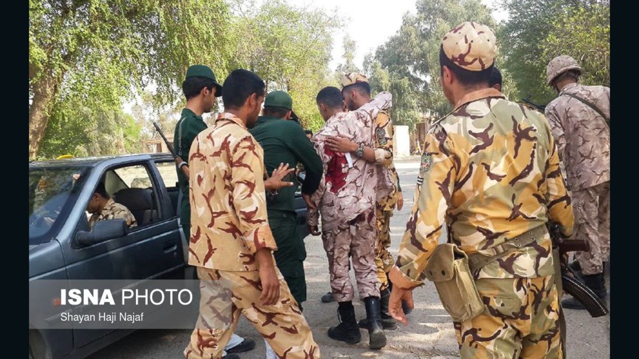 A soldier wounded in the attack is treated Saturday at the scene in Ahvaz.