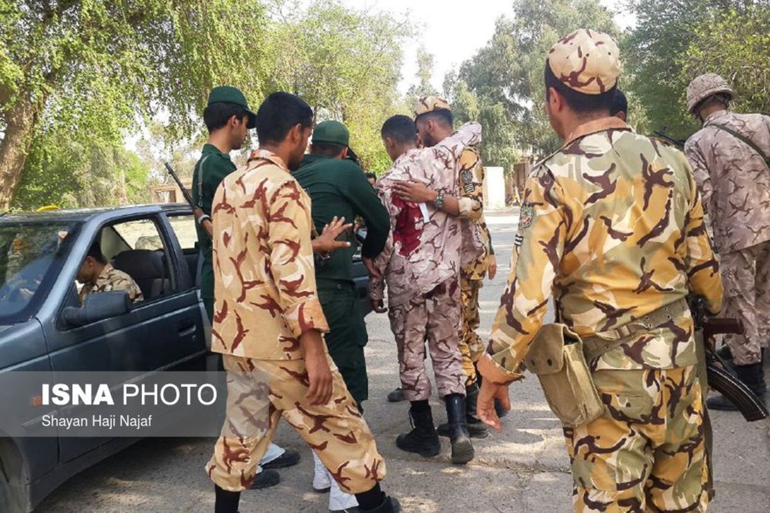 A soldier wounded in the attack is treated Saturday at the scene in Ahvaz.