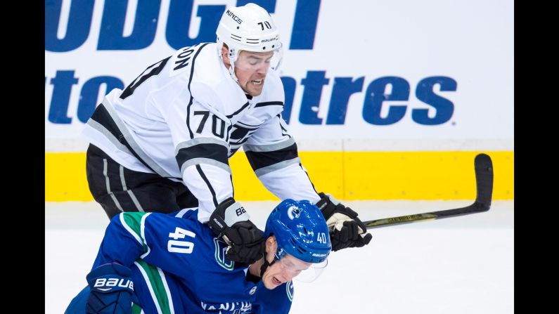 Tanner Pearson of the Los Angeles Kings checks Elias Pettersson of the Vancouver Canucks during the first period of an NHL hockey preseason game Thursday, September 20, in Vancouver, British Columbia.