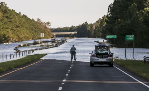 An officer with the South Carolina State Highway Patrol marks the water level of Highway 22 on Saturday.