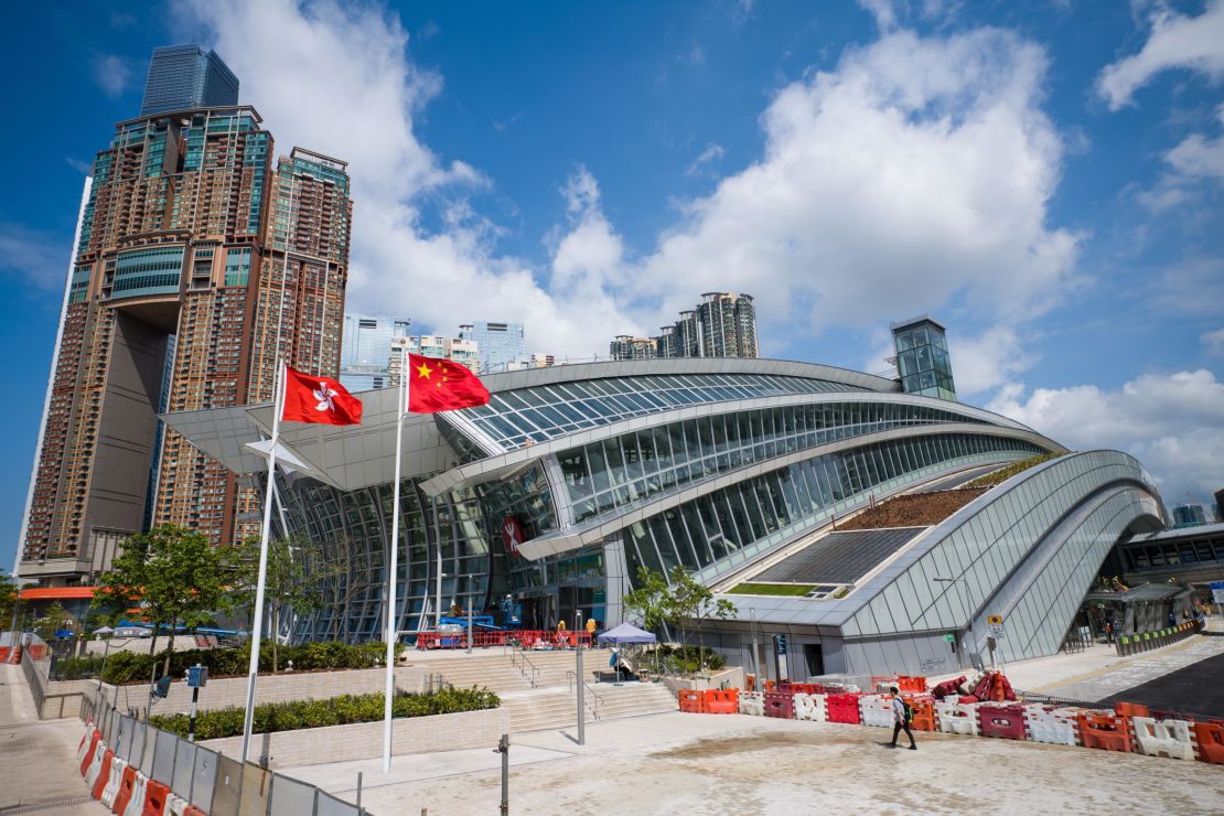 The flags of Hong Kong (L) and China are seen hoisted outside the West Kowloon train station of the High Speed Rail Link to Guangzhou as sales counters were opened to the public for the first time in Hong Kong on September 10, 2018. 