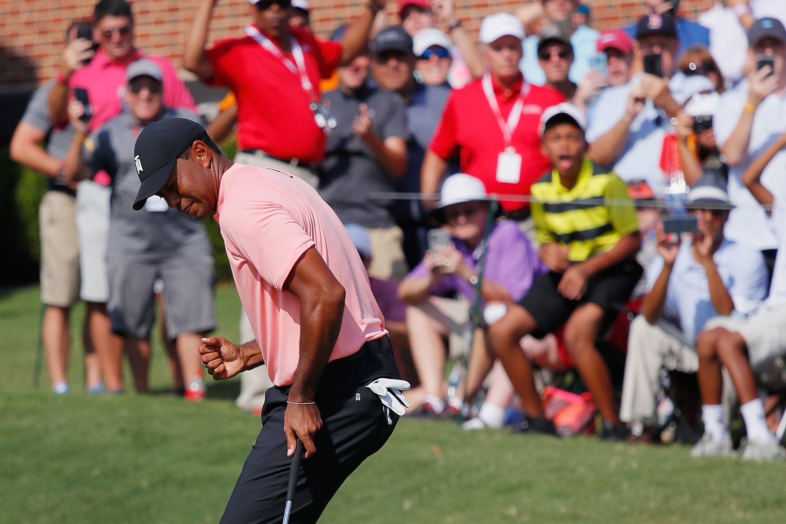 Woods celebrates after making an eagle putt on 18 on Thursday during the first round.