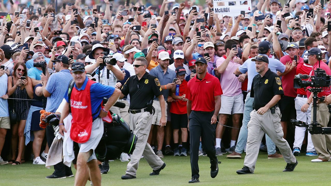 Tiger Woods is swarmed by fans as he walks to the 18th green during the final round of the TOUR Championship.