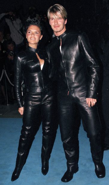 David and Victoria Beckham (then Victoria Adams) wearing matching leather Versace to a Versace store opening in 1999. 
