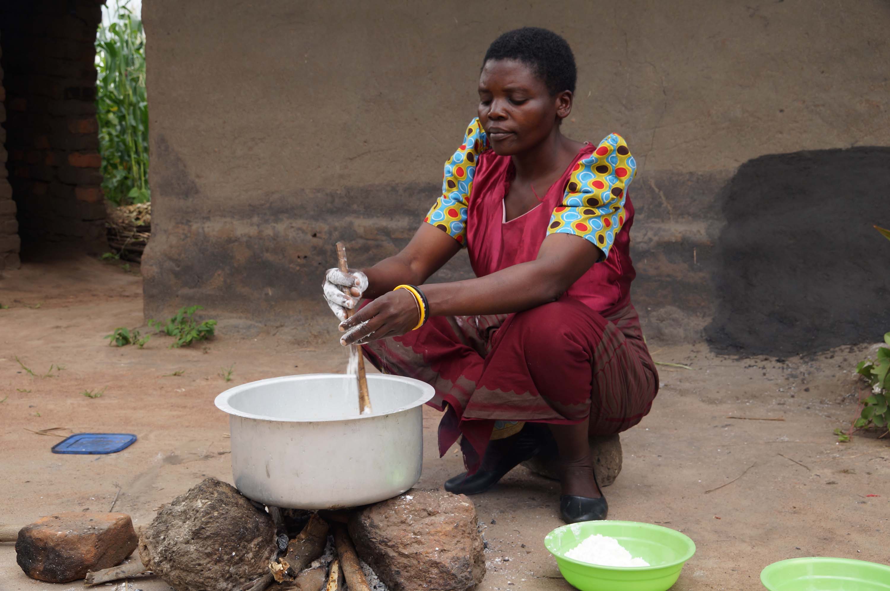 Margret Kawala preparing porridge at her home.