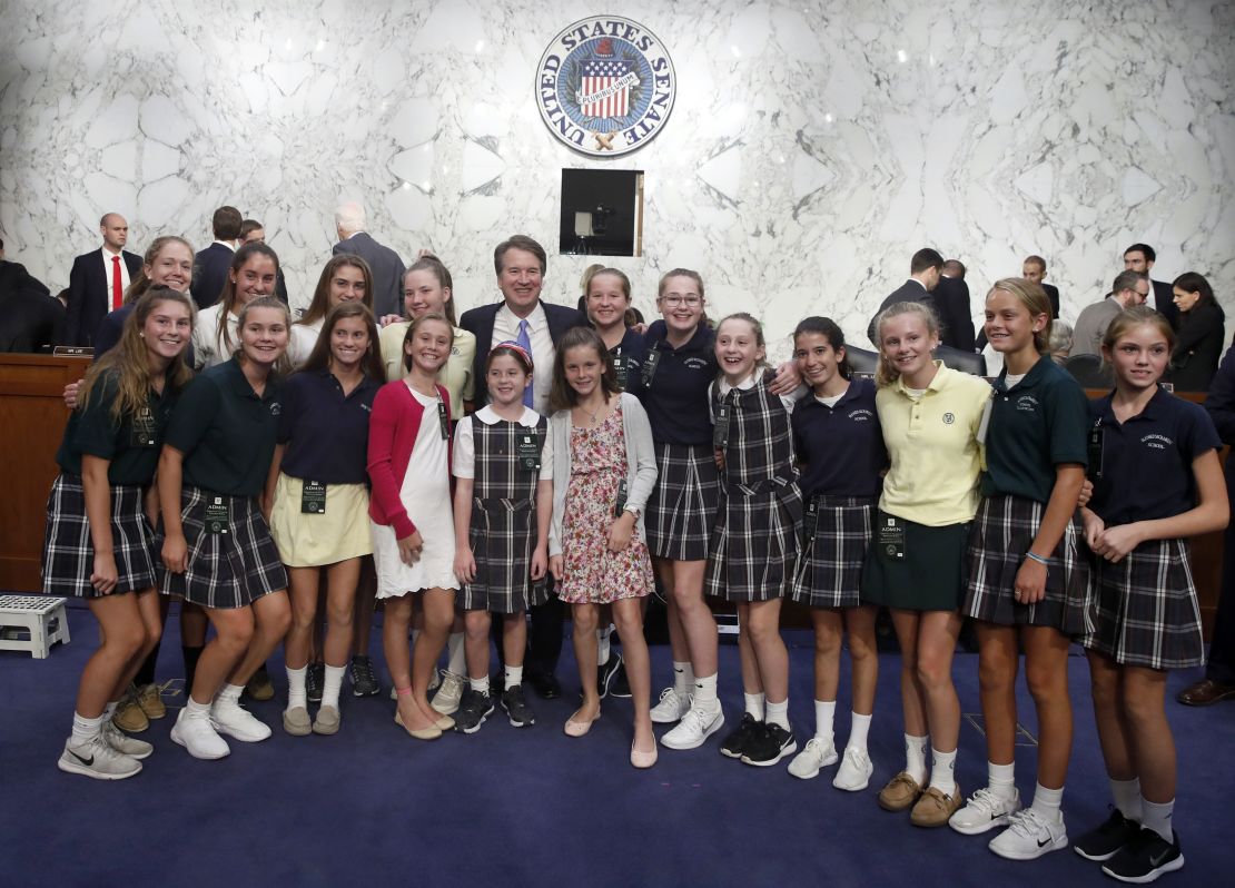 Brett Kavanaugh poses with current and former basketball team members he coaches at a Senate Judiciary Committee hearing on Capitol Hill.