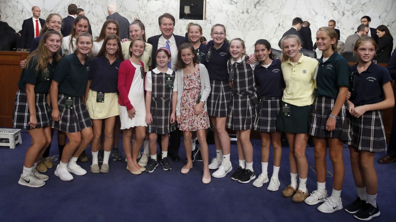 Brett Kavanaugh poses with current and former basketball team members he coaches at a Senate Judiciary Committee hearing on Capitol Hill.