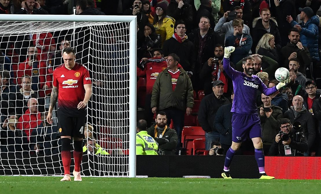 Manchester United's Phil Jones (L) leaves the pitch after Derby's goalkeeper Scott Carson (C) saved his penalty.