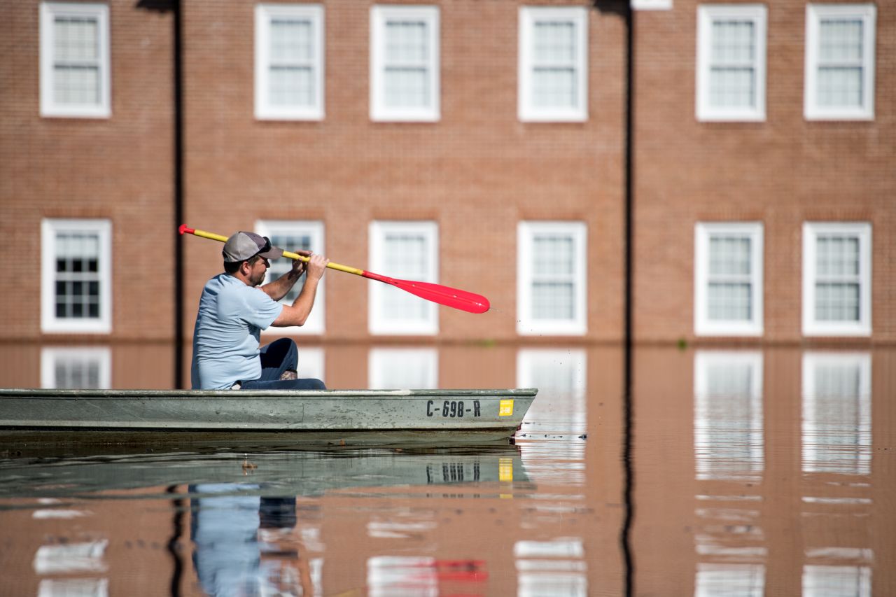 Taylor James navigates floodwaters in a boat in front of Trinity United Methodist Church in Conway, South Carolina on Wednesday, September 26.