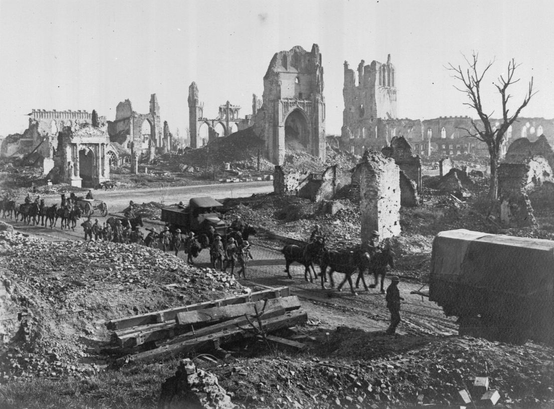 Horses and men of 1st Anzac Corps on their way past the ruins of the Cathedral and Cloth Hall in Ypres, France.