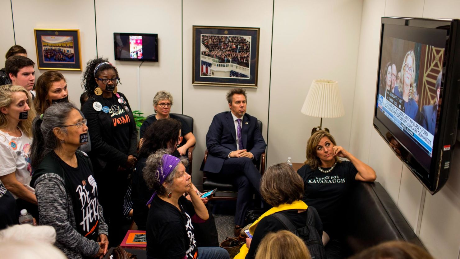 In this September 27, 2018, file photo, Protesters and supporters of Supreme Court Nominee Brett Kavanaugh watch Christine Blasey Ford's testimony from Sen. Chuck Grassley's office in Washington. 