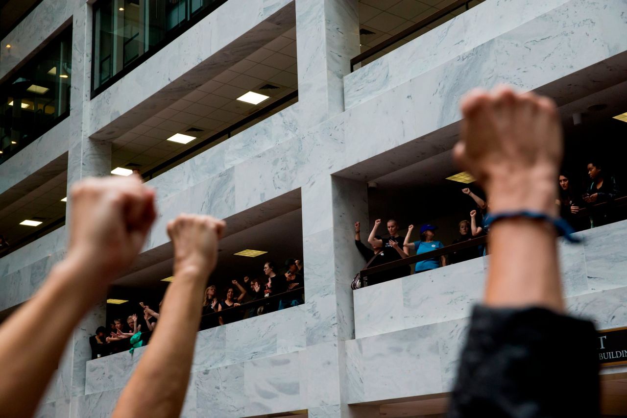 People protest against Kavanaugh at the Hart Senate Office Building on Thursday. Many silently protested in the halls — <a href="https://www.cnn.com/politics/live-news/kavanaugh-ford-sexual-assault-hearing/h_4a493a75d6e20a57ea979b38788b1e6b" target="_blank">and even the elevators</a> — outside the hearing room.