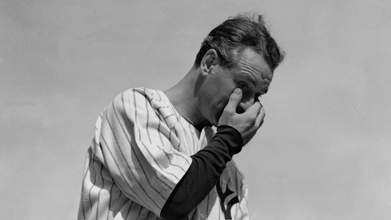 New York Yankees' Lou Gehrig wipes away a tear while speaking during a sold-out tribute at Yankee Stadium on July 4, 1939. Gehrig's record breaking career was cut short by neuromuscular disease.