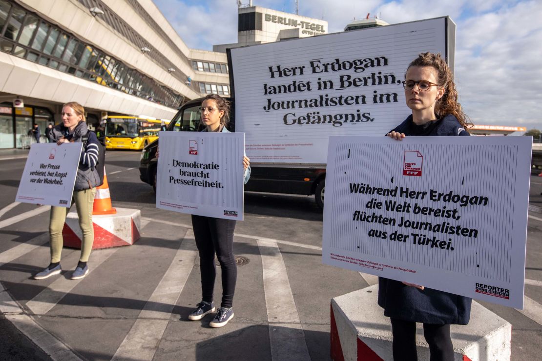Demonstrators hold signs calling for freedom of the press in Turkey during a protest outside Tegel airport in Berlin on Thursday.