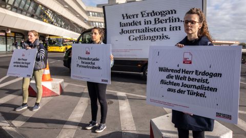 Demonstrators hold signs calling for freedom of the press in Turkey during a demonstration outside Berlin's Tegel Airport on Thursday.