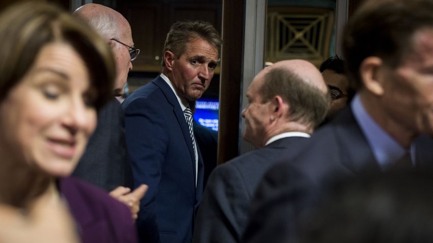 Sen. Jeff Flake  exits the Senate Judiciary Committee meeting about the Supreme Court nominee Brett Kavanaugh, Sept. 28, 2018. 