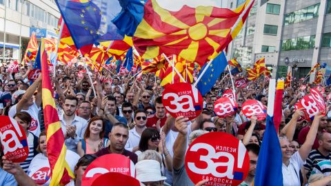 People wave Macedonian and European flags as they attend a rally for the "yes" campaign.