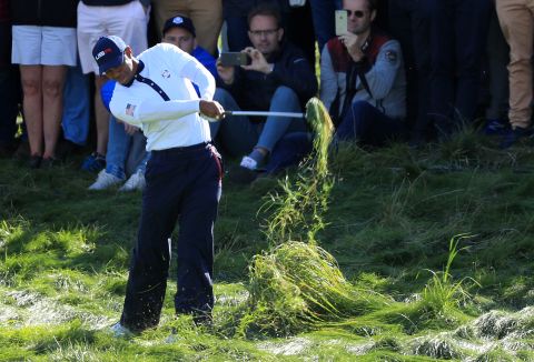 Team USA's Woods hits from the rough during a Saturday foursomes match.