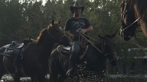 Patrick Mckann on horseback pulls another horse behind him this week in Conway, South Carolina. 