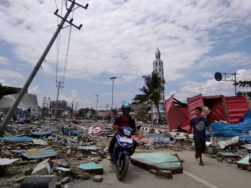 Palu residents make their way along a street full of debris on September 29. Palu is a coastal city of about 350,000.
