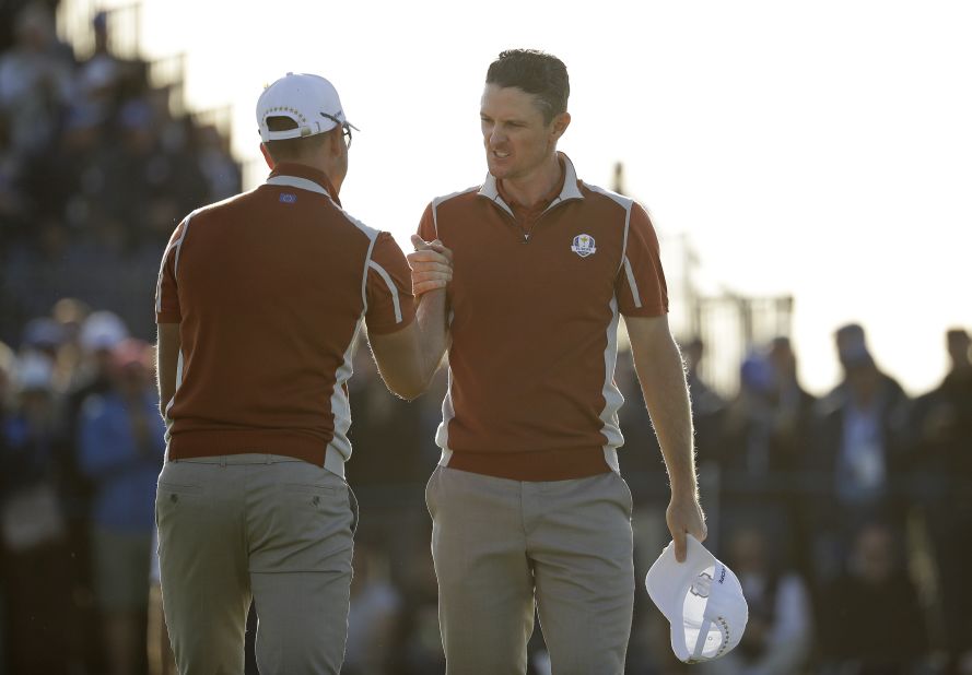 Europe's Justin Rose, right, celebrates with teammate Henrik Stenson on the 17th green after winning a foursomes match Saturday.