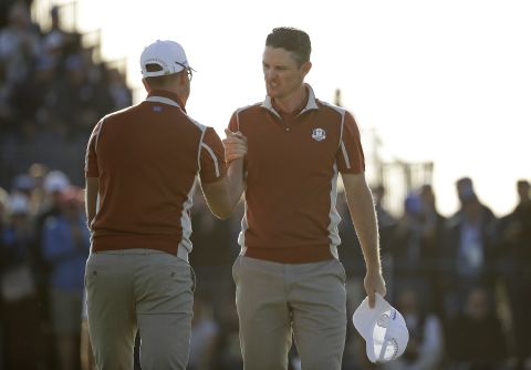 Europe's Justin Rose, right, celebrates with teammate Henrik Stenson on the 17th green after winning a foursomes match Saturday.