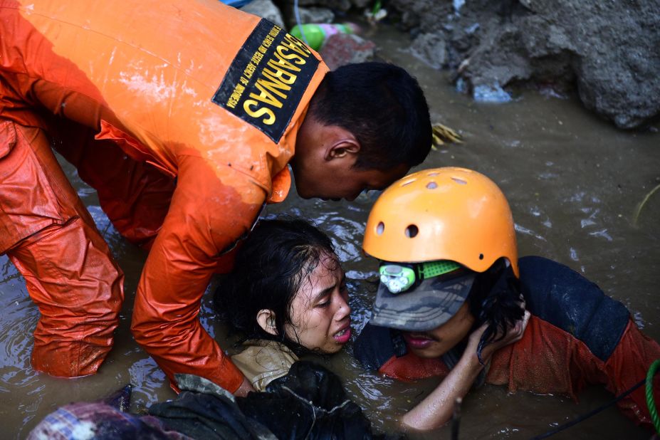Rescuers try to free a 15-year-old earthquake survivor who was trapped in the flooded ruins of a collapsed house in Palu on Sunday, September 30.